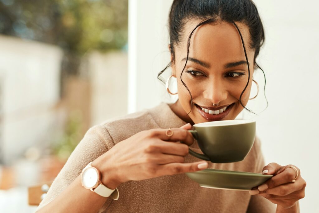 Cropped shot of an attractive young woman sitting alone in her home and enjoying a cup of coffee